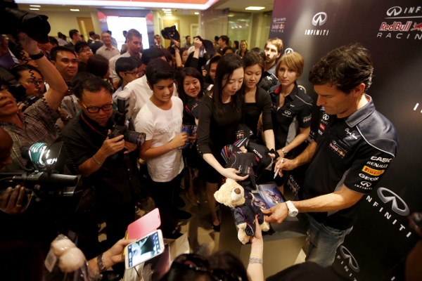 Mark Webber signs autographs at an event at the OCBC Center in Singapore.